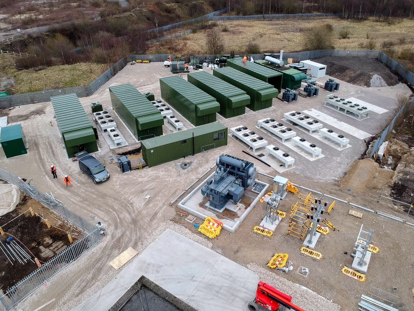 Dmeco site deployment — multiple genset acoustic enclosures with remote radiators and switchgear at a power generation facility